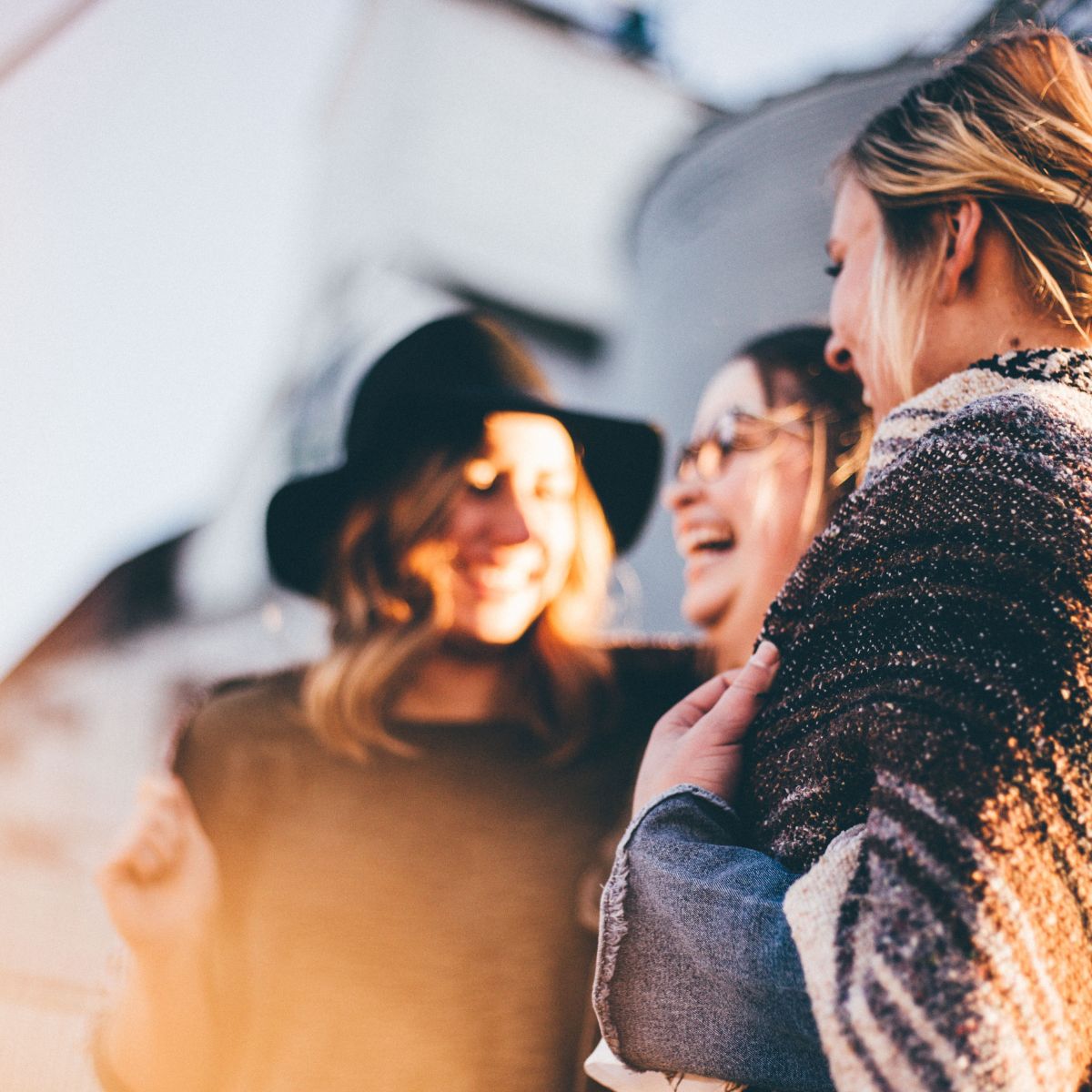 A group of women laughing and talking outdoors, symbolizing open and supportive conversations about fertility preservation and egg freezing choices.