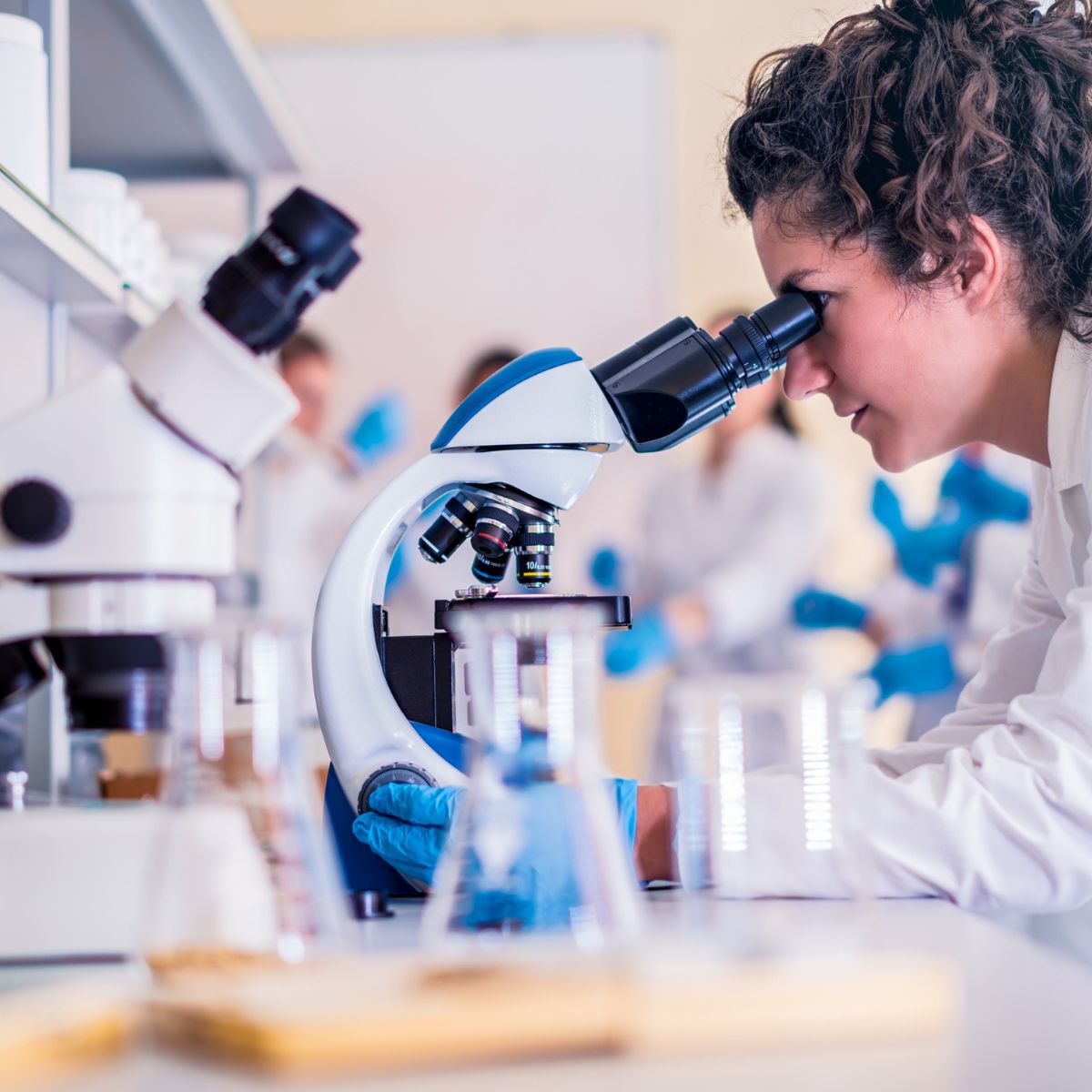 Senior embryologist examining samples under a microscope in a fertility lab, showcasing the precision and expertise involved in fertility treatments and egg freezing procedures.