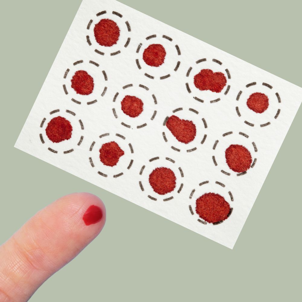 Blood sample collection card for at-home fertility testing showing completed blood drops.