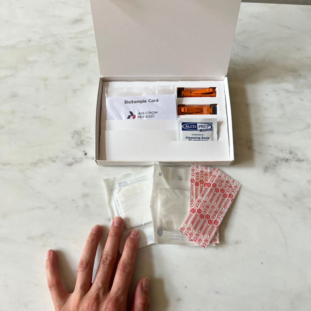 Fertility test home kit with sample collection items including lancets, alcohol wipes, and blood sample card, demonstrating step 2 of the at-home test process for AMH hormone testing.