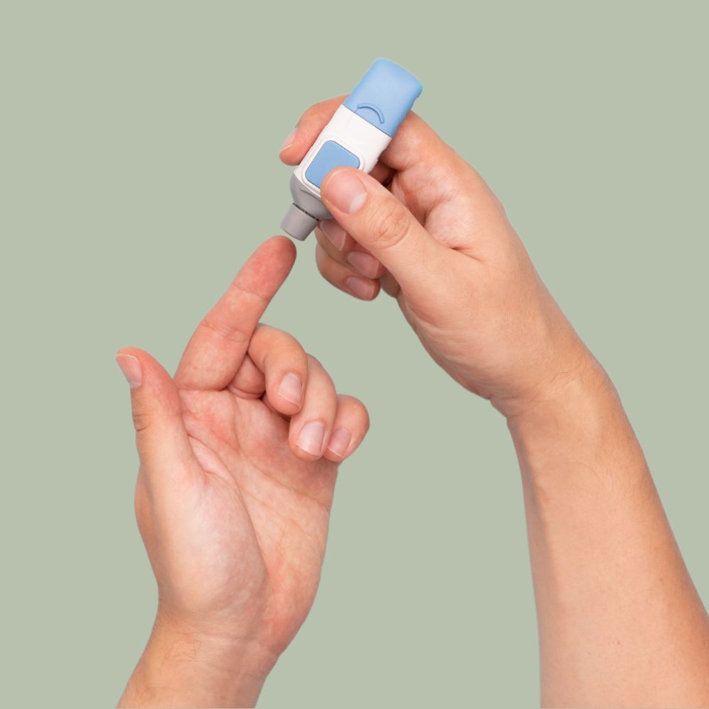 Hand using a lancing device for at-home fertility test blood sample collection.